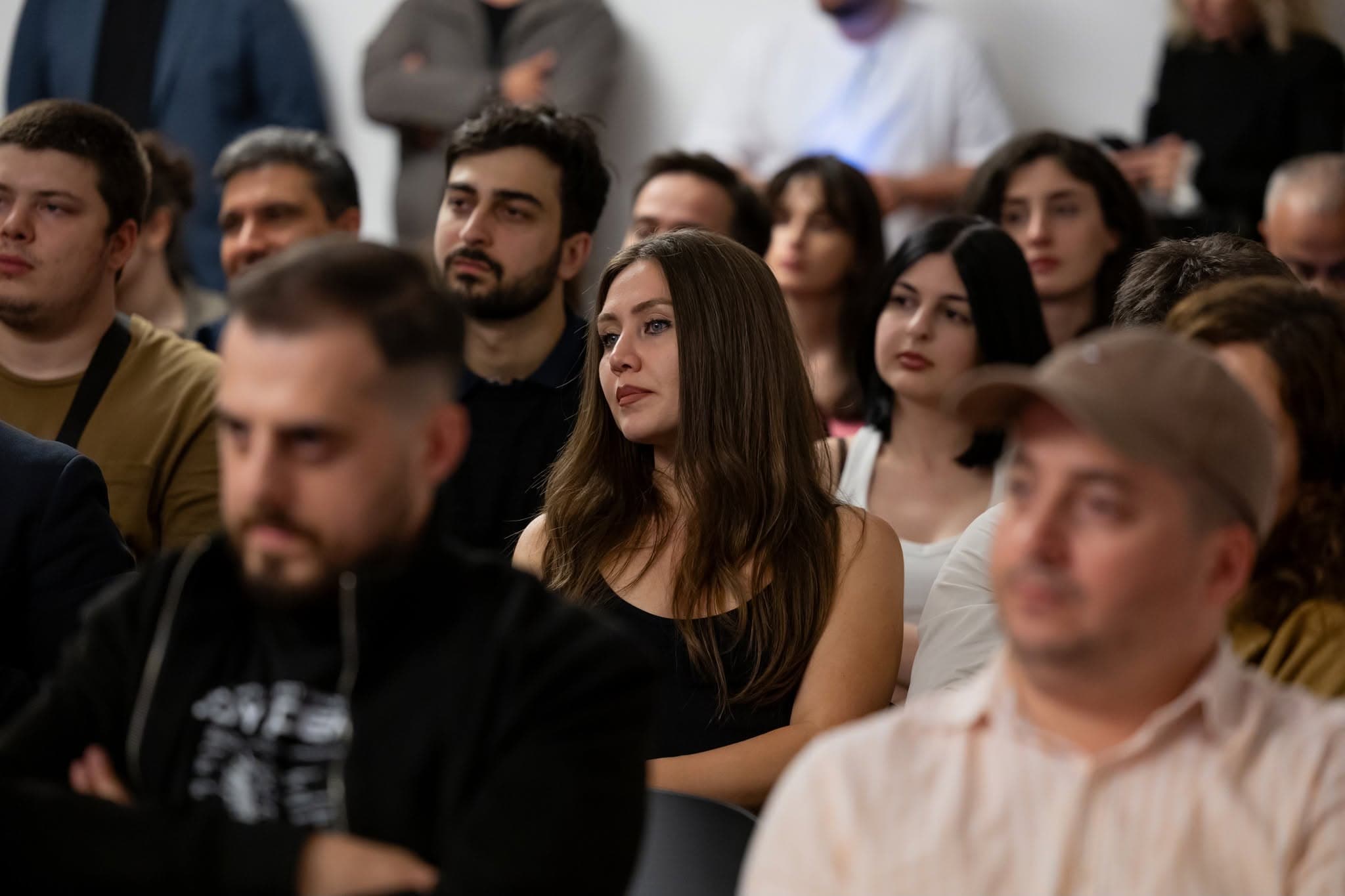 მონაწილეები ყურადღებით უსმენენ სპიკერს